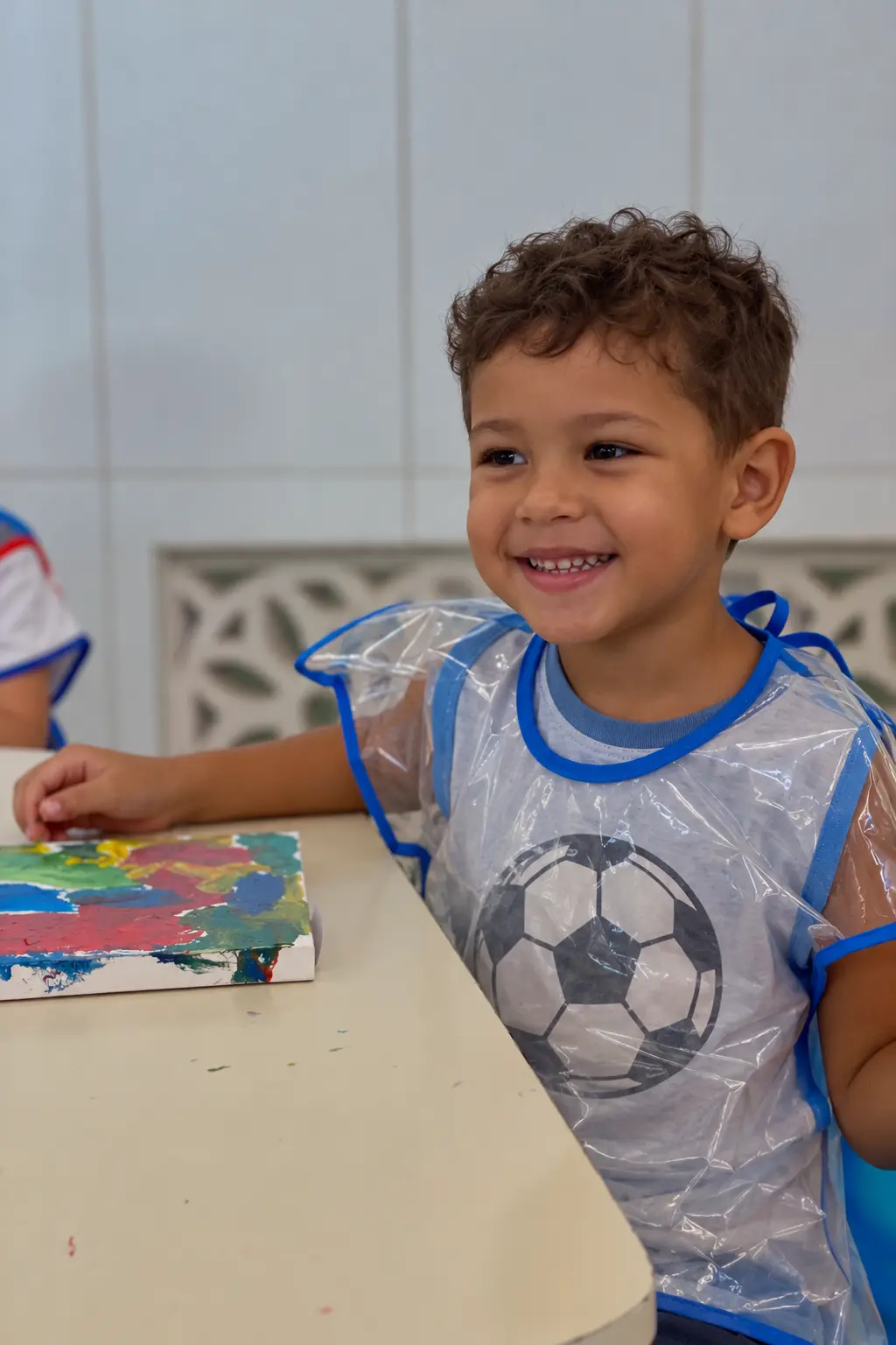 Aluno da Educação Infantil pintando uma tela